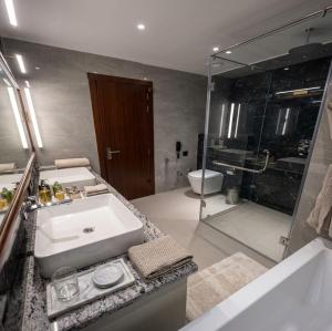 a bathroom with a white sink and a shower at Comfort Hotel Kishore Azamgarh in Āzamgarh +18 photos