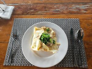 a white plate with a slice of pizza on a table at Tanawin BnB in Orani +20 photos