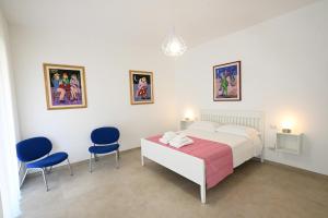 a bedroom with a bed and two blue chairs at MELO 48 in Bari