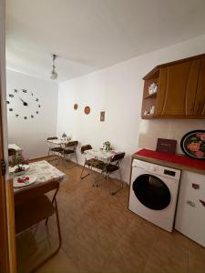 a kitchen with a dishwasher and a table with chairs at Xhulio Guesthouse Berat in Berat