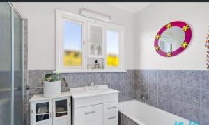 a bathroom with a sink and a tub and a mirror at Timber and Tide in Saint Leonards