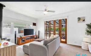 a living room with a couch and a tv at Timber and Tide in Saint Leonards