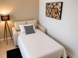 a small bedroom with a bed and a couch at Charmoso apartamento na Lapa in Rio de Janeiro