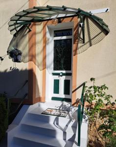 a door of a house with a stairway leading to a doorway at la villa des chats in Andrésy