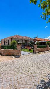 a house with a brick driveway in front of a building at Mlinova Küçükköy in Ayvalık
