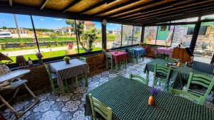 a restaurant with tables and chairs and windows at Mlinova Küçükköy in Ayvalık