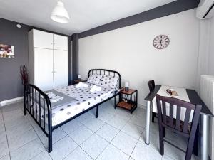 ein Schlafzimmer mit einem Bett, einem Tisch und einer Uhr in der Unterkunft Martheo Studios 2 in Mytilini