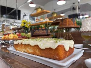 a cake sitting on a white plate on a table at Hotel Recanto dos Dinossauros in Penha +107 photos