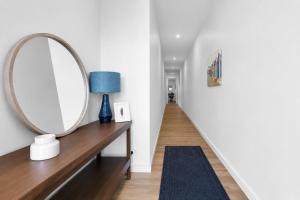 a hallway with a mirror and a table with a blue lamp at Albert Samian Retreat by Ready Set Stay - BYO sheets and towels in Capel Sound +12 photos