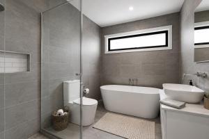 a bathroom with a tub and a toilet and a sink at Albert Samian Retreat by Ready Set Stay - BYO sheets and towels in Capel Sound