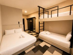 two beds in a room with two bunk beds at the youniQ Hotel, KLIA T1, KLIA T2 in Sepang