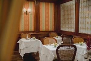 a dining room with tables and chairs with white table cloth at Sina Palazzo Sant'Angelo in Venice +20 photos