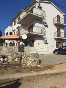 a building with a car parked in front of it at Apartman Lidija in Linardići