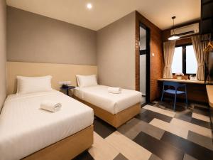 a hotel room with two beds and a desk at the youniQ Hotel, KLIA T1, KLIA T2 in Sepang +7 photos
