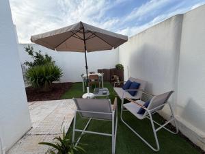 a patio with two chairs and an umbrella at Casa da Tininha in Alcobaça