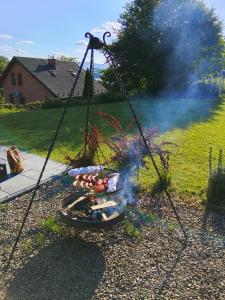 a grill with a bunch of hot dogs on it at Slow Lake House Koszarka in Gródek Nad Dunajcem