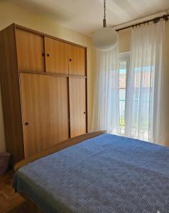 a bedroom with a bed and a cabinet and a window at Rooms LuaMar in Sali