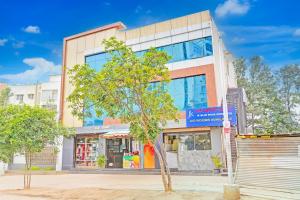 a building with a tree in front of it at Hotel O JK Blue Rock Comforts in Bangalore +21 photos