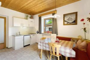a kitchen and living room with a table and a kitchen and a table and chairs at THALERHOF Onach Dolomites - Kronplatz in San Lorenzo di Sebato