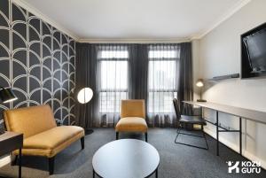 a living room with a couch and chairs and a tv at KozyGuru | Sydney CBD | Best Location Studio in Sydney