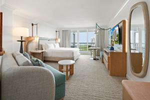 a hotel room with a couch and a bed at Naples Grande Beach Resort in Naples