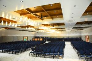 a large hall with blue chairs and a chandelier at Chitra's City Side Resort in Solapur +51 photos