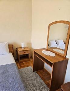 a bedroom with a mirror and a bed and a desk at Rooms LuaMar in Sali