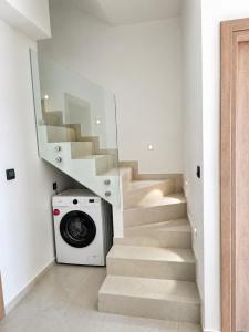 a laundry room with a washing machine and stairs at Elina's Era Lounge Apartment in Palekastron