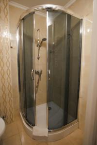 a shower with a glass door in a bathroom at City Center Residence in Chernivtsi