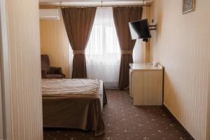 a hotel room with a bed and a television at City Center Residence in Chernivtsi