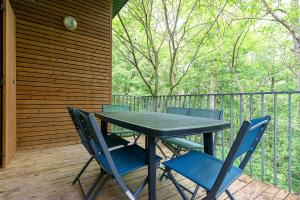 a table and chairs on a deck with a fence at Les Charmes C15 - Le Val Joly in Eppe-Sauvage +7 photos