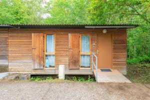 a wooden cabin with a porch and a door at Les Charmes C15 - Le Val Joly in Eppe-Sauvage