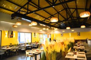 a restaurant with tables and chairs with yellow walls at Chitra's City Side Resort in Solapur