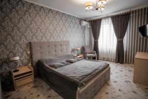 a bedroom with a bed and a chair in it at City Center Residence in Chernivtsi