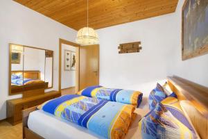 a bedroom with two beds and a mirror at THALERHOF Onach Dolomites - Kronplatz in San Lorenzo di Sebato