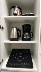 a stove in a kitchen with a pot and a tea kettle at Charmoso apartamento na Lapa in Rio de Janeiro