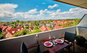 a table on a balcony with a view of a city at FeWo Sonnenschein mit Pool & Balkon in Horumersiel