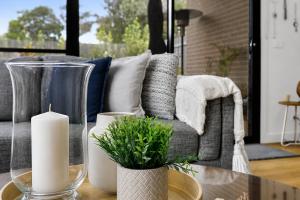 a living room with a couch and a table with candles at Albert Samian Retreat by Ready Set Stay - BYO sheets and towels in Capel Sound