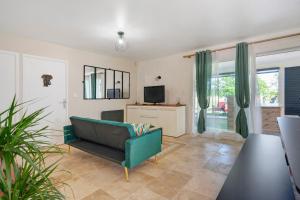 a living room with a couch and a tv at La Casa Andréa in Villars-en-Pons