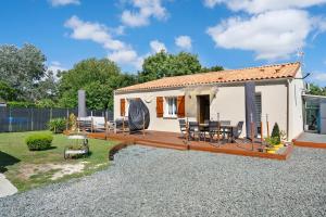 a small cottage with a deck and chairs in a yard at La Casa Andréa in Villars-en-Pons