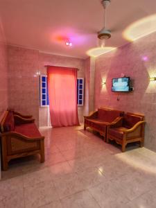 a living room with two benches and a red curtain at See you soon blue Beach in Marsa Matruh