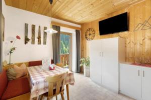 a kitchen and dining room with a table and a television at THALERHOF Onach Dolomites - Kronplatz in San Lorenzo di Sebato