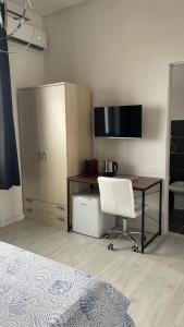 a bedroom with a desk and a chair next to a bed at Camera in centro storico in Olbia