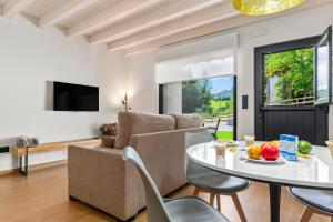 a living room with a table and a couch at Apartamentos el Caneyón in San Juan de Parres