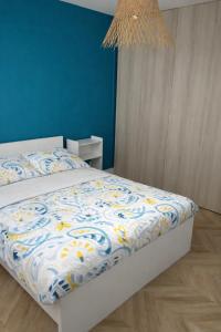 a bedroom with a bed with a blue wall at Chambre privée proche centre ville in Caen