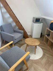 a living room with a couch and a chair and a table at Chambre privée proche centre ville in Caen