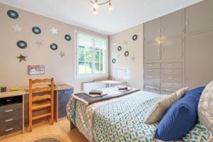 a bedroom with a bed and a desk and a window at La Jardinette - Avec jacuzzi privé in Futeau