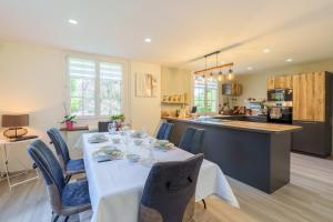 a dining room and kitchen with a table and chairs at La Jardinette - Avec jacuzzi privé in Futeau +10 photos