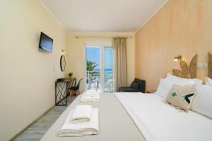 a hotel room with a bed with a view of the ocean at OzioMari Suites in Limenaria