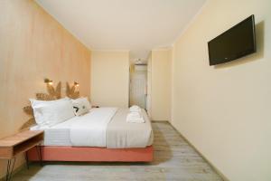 a bedroom with a bed and a flat screen tv at OzioMari Suites in Limenaria +33 photos